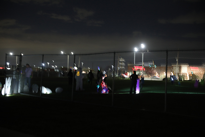 Attendees use flashlights at night to find eggs.