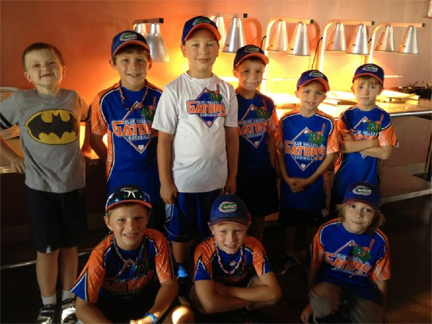 Group of boys in their baseball uniforms posing for the camera.