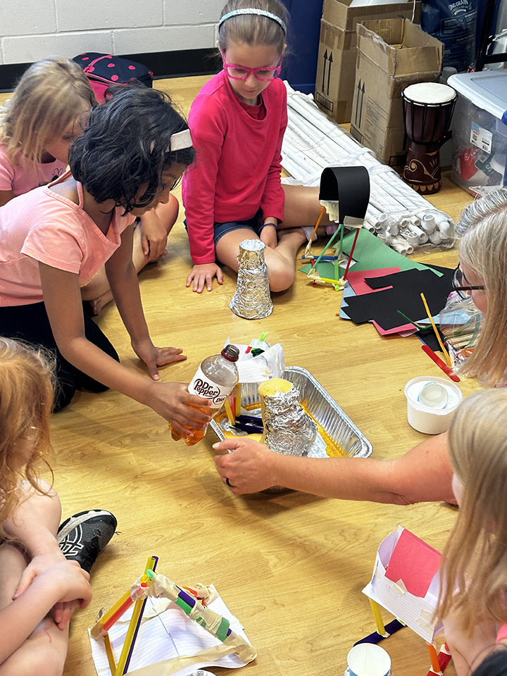 Kids demonstrate how to make a volcano erupt.