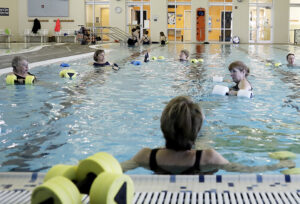 A group of women doing a aqua fitness exercise in the pool.
