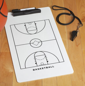 A clipboard with a whistle and basketball.