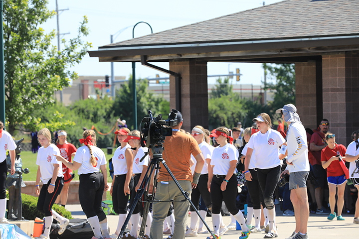 Members of a youth softball team pose for a tv station interview at the Sports Complex.
