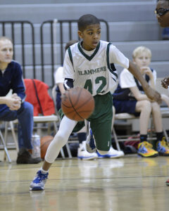 A young male dribbles a basketball.