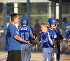 A coach congratulates a player during a youth baseball tournament at Blue Valley Rec Sports Complex.