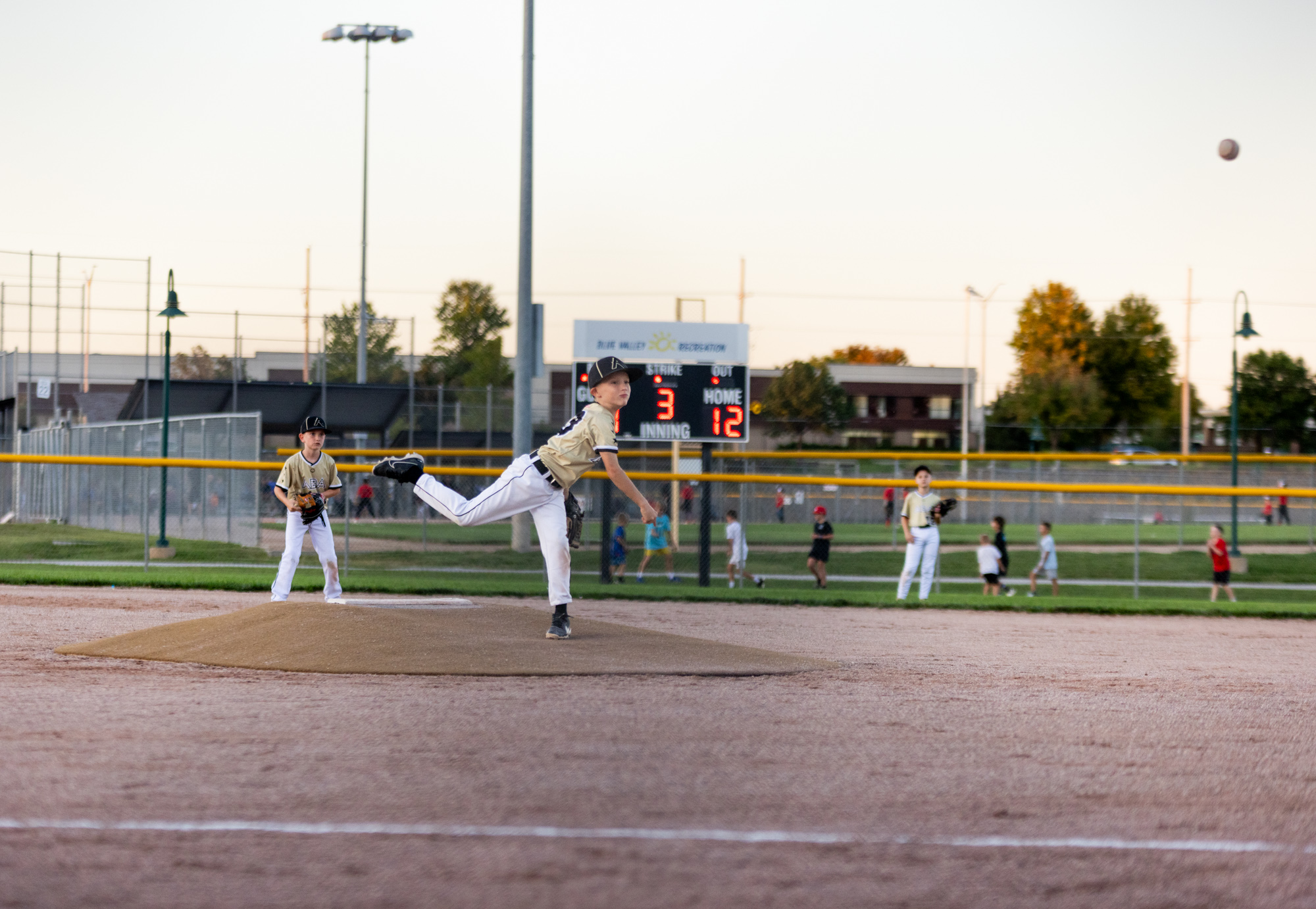 A young baseball player warms up on the pitching mound.