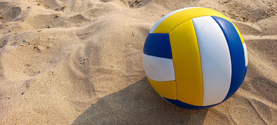 Volleyball lying on sand.