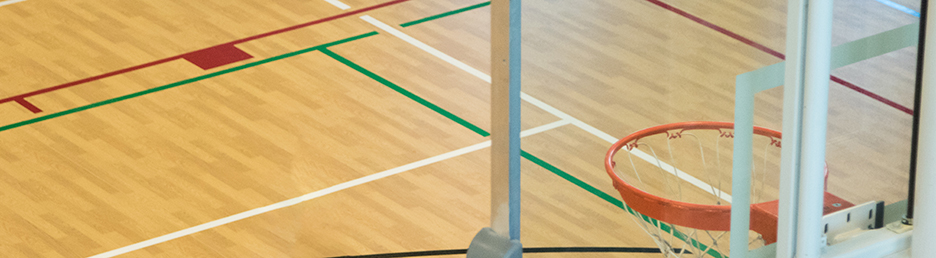 The side of a basketball goal with the court showing through it.