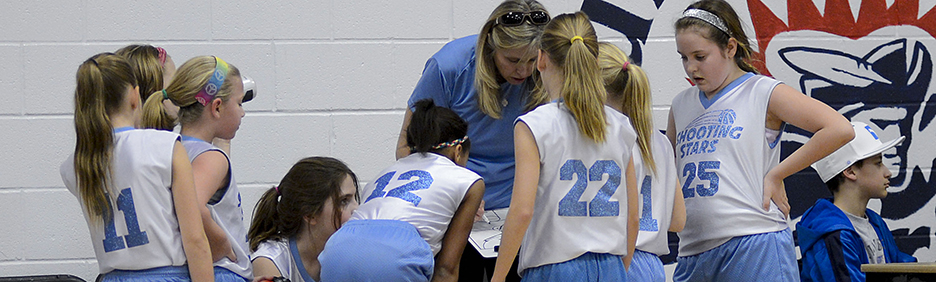 Girl basketball players in a huddle during a timeout.