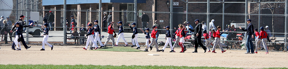 Two youth baseball teams shake hands after a game.
