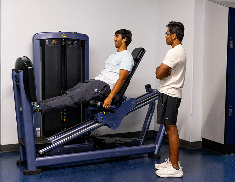 A man uses a seated leg press.
