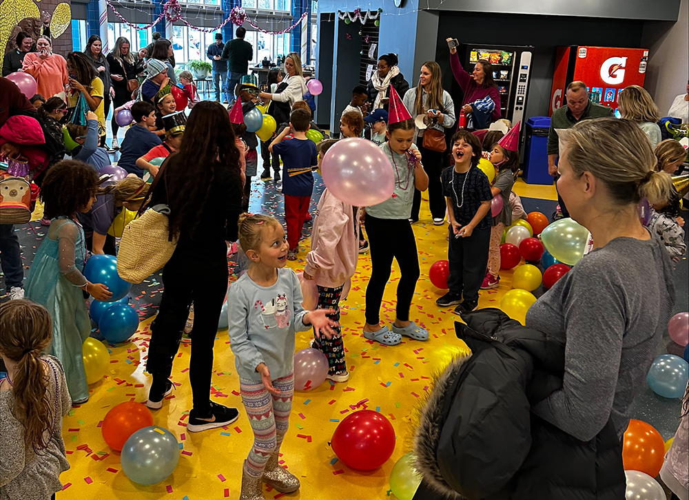 Kids popping balloons and throwing confetti.