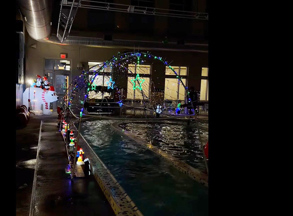A lighted arch spans across the lazy river in the pool area.