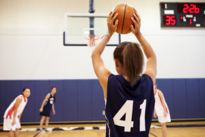 A female basketball players gets ready to pass the ball to a team mate.