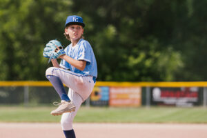 A pitcher starts his wind up.