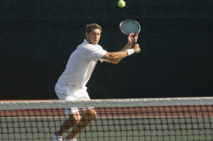 Adult tennis player preparing a two-handed backhand shot on an outdoor tennis court