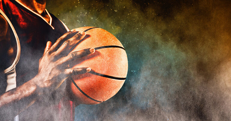 A player holding a basketball to his chest.